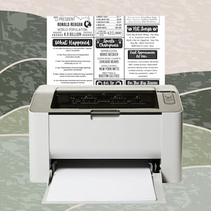 May include: A white printer with a printed page featuring text about historical events, sports champions, and hit songs. The text includes "President Ronald Reagan", "Wimbledon Boris Becker", and "NBA Finals Boston Celtics". The printer is on a patterned background.