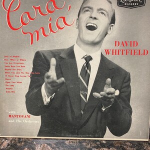 May include: Vintage vinyl record album cover featuring David Whitfield, titled "Cara, Mia." The cover has a black and white photo of Whitfield singing, with red text. The London Records logo is visible.
