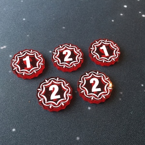 May include: Five red plastic game pieces with white numbers. The numbers are 1, 2, 2, 2, and 1.