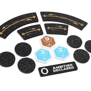 May include: A set of game pieces for a space-themed board game. The pieces include black and gold spaceship movement tokens, black and white numbered tokens, and a black token with the text "Ambition Declared".