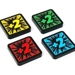 May include: Four square game tiles with black borders and a white starburst design. Each tile has a different coloured background: yellow, green, blue, and red. The number "2" is printed in white on the yellow tile, green on the green tile, blue on the blue tile, and red on the red tile. The text "+2" is printed in black on each tile.