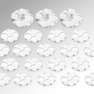 May include: A collection of white, circular, interlocking plastic pieces. The pieces have a unique design with multiple curved sections and circular openings. The arrangement suggests a modular or building-block type of product.