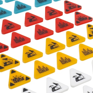 May include: A set of triangular game pieces in various colours, including red, yellow, blue, and white. Each piece features a black graphic design, such as a building, a bird, or a wave.