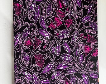 Op de afbeelding: Een stof met een bloemenpatroon. Het patroon toont roze en paarse bloemen en bladeren op een zwarte achtergrond. Het ontwerp bevat witte contouren en details, waardoor een gedetailleerde stof ontstaat.