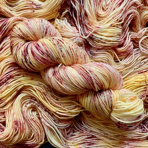 Peut inclure: Une pelote de laine dans un coloris jaune et rouge. La laine est de couleur variée, avec des nuances de jaune, d'orange et de rouge. La laine est douce et moelleuse, et elle serait parfaite pour le tricot ou le crochet.