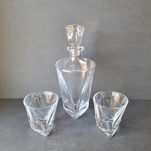 Peut inclure: Un ensemble de trois carafes et verres en verre transparent avec un design géométrique. La carafe a un bouchon carré.