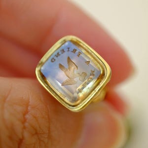 Llavero con sello victoriano con inscripción "FROM A FRIEND" en forma de paloma sobre cadena de plata bañada en oro. Joya romántica antigua.