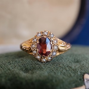 Anillo victoriano de oro de 15 quilates con granate y perla, c. 1875-1876.