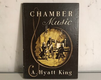 以下が含まれることがあります： A. Hyatt King 著「室内楽」というタイトルの茶色の本。表紙には、ろうそくのある部屋で演奏する3人組の音楽家の金色のイラストが描かれている。