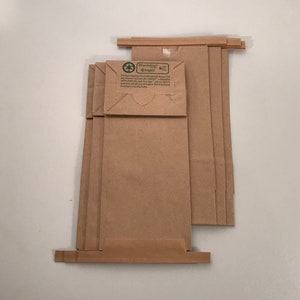 May include: A stack of six brown paper bags with a green and white label that reads "Earthwise" and "Wrappers".