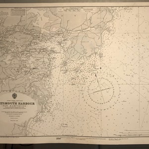May include: A vintage nautical chart of Portsmouth Harbour, New Hampshire, with detailed markings and depth soundings. The chart includes a compass rose and a scale bar.