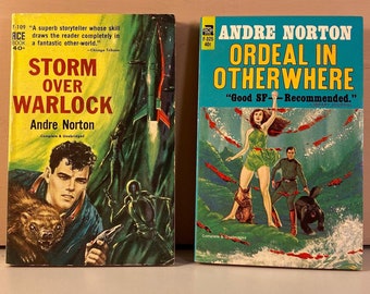 May include: Two vintage science fiction paperback books by Andre Norton. The book on the left is titled "Storm Over Warlock" and features a green and blue cover with a rocket ship and a man with a furry animal. The book on the right is titled "Ordeal in Otherwhere" and features a blue and green cover with a woman in a green dress and a man in a blue shirt standing in a body of water with red fish.