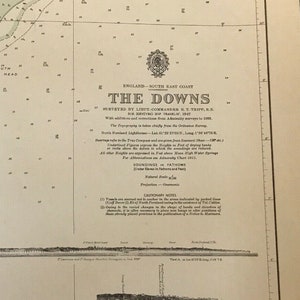 May include: A vintage nautical chart of The Downs, England, published in 1828. The chart features detailed markings and annotations, including depth soundings, navigational aids, and coastal features. The title "The Downs" is prominently displayed at the top of the chart.