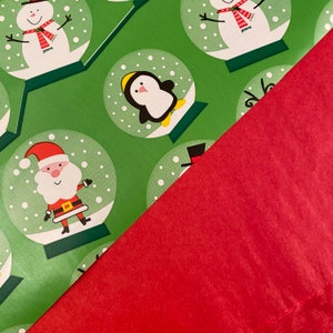 Pu&ograve; includere: Carta da regalo verde con un motivo ripetitivo di palle di neve. Ogni palla presenta un personaggio invernale diverso, tra cui un pupazzo di neve, un pinguino e Babbo Natale. La carta &egrave; parzialmente coperta da un foglio di carta rosso solido.