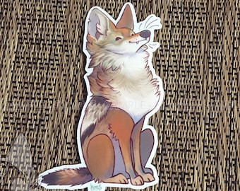 May include: A sticker of a cartoon coyote with brown, white, and black fur. The coyote is sitting with its head tilted up and its mouth slightly open. The sticker has a white background and is printed with a signature in the bottom left corner.