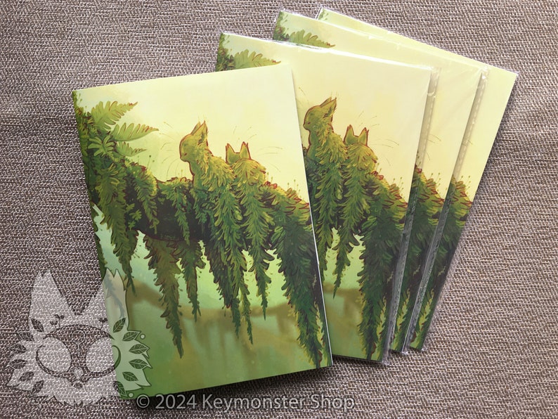 May include: A set of five cards featuring a whimsical illustration of two green, furry creatures sitting on a branch with hanging ferns. The background is a soft yellow with a green gradient.