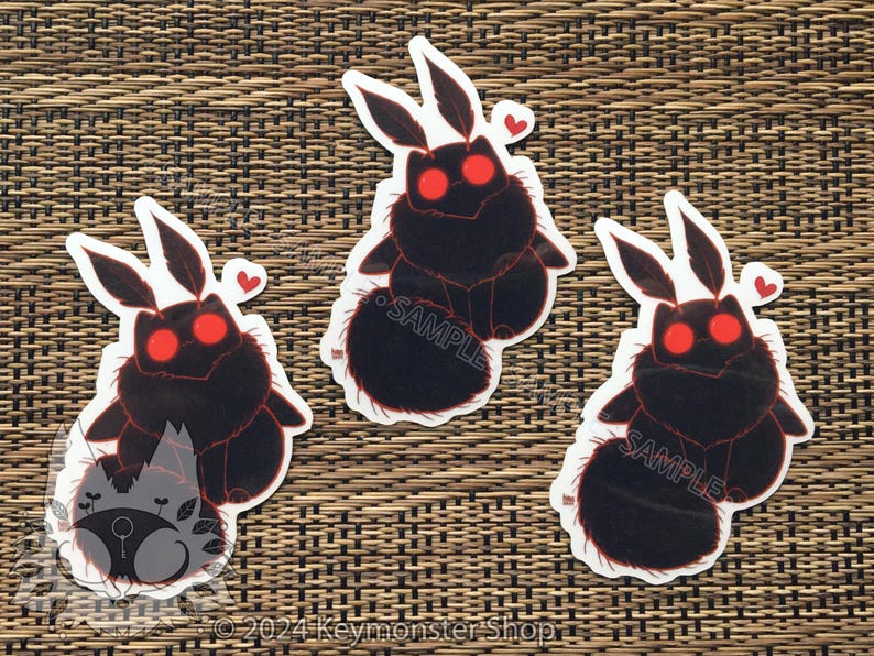 May include: Three black and red moth stickers with a fuzzy texture and red eyes. The stickers have the word "SAMPLE" printed on them.