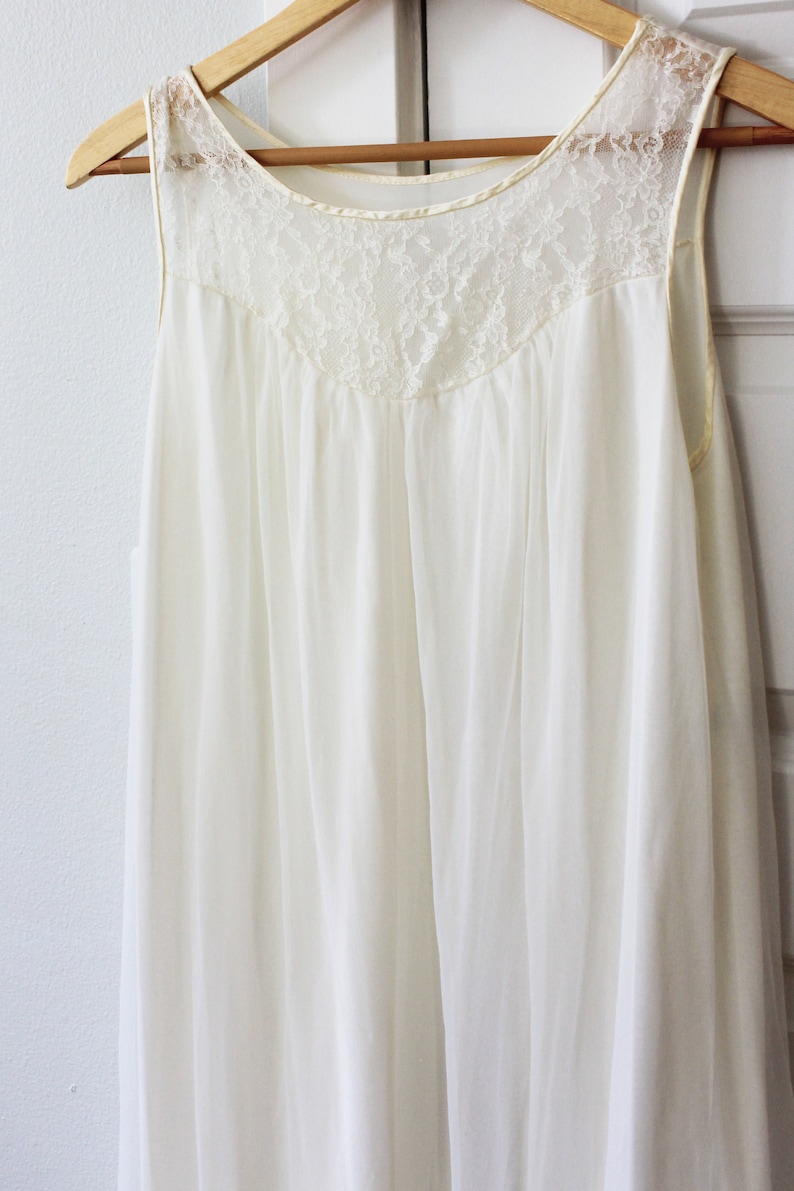 May include: A white sleeveless nightgown with a lace neckline.