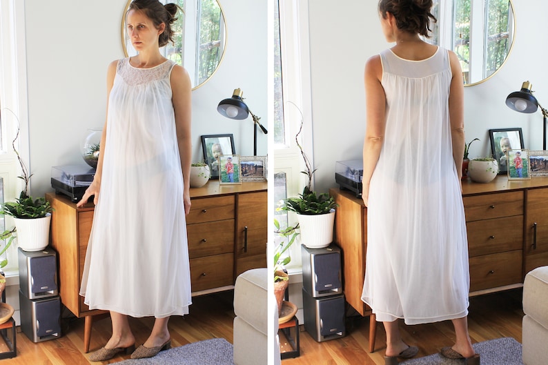 May include: A white sleeveless nightgown with a lace trim around the neckline. The nightgown is made of a sheer fabric and has a flowing silhouette.
