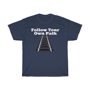 May include: A navy blue t-shirt with the text "Follow Your Own Path" in white lettering. A black and white illustration of a set of railroad tracks is below the text.