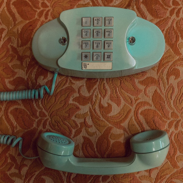Print | Antique Light Teal Touchtone Phone Unhung on Muted Orange Mid Century Modern Furniture with Floral Pattern | Print taken in Chicago