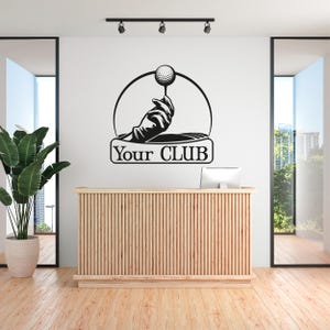 Pode incluir: Silhueta preta e branca de uma mão segurando uma bola de golfe em um tee. O texto "Your CLUB" está abaixo da imagem.
