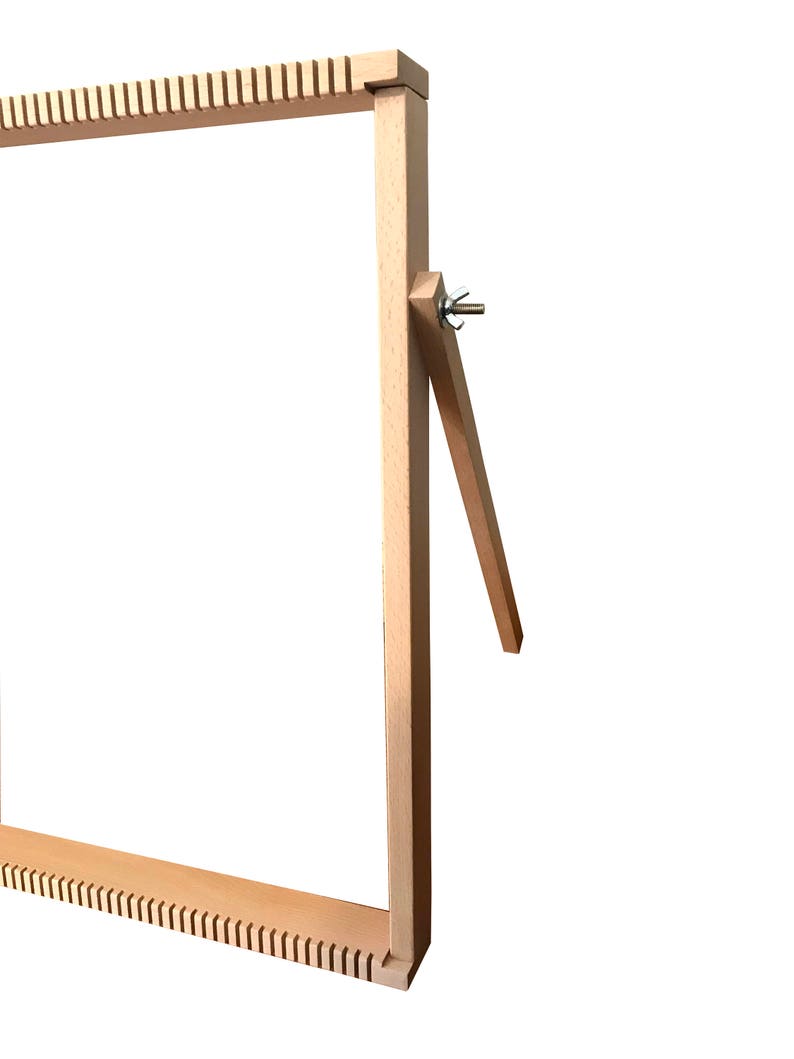May include: A wooden loom with a natural finish. The loom has a rectangular frame with a tensioning system on one side. The loom is designed for weaving small projects.