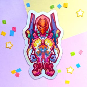 May include: A holographic sticker featuring a cartoon illustration of a red and orange robot with a smaller figure of a girl in a red and white suit inside. The robot has a yellow and orange face with a red helmet.