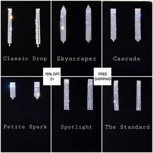 May include: A collection of six pairs of sparkling rhinestone earrings on a black background. Styles include Classic Drop, Skyscraper, Cascade, Petite Spark, Spotlight, and The Standard. Each pair features a different design, with varying lengths and shapes.
