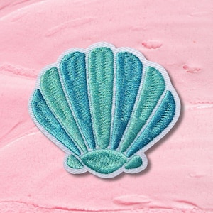 Könnte beinhalten: Gestickter Muschel-Aufnäher in Türkis- und Türkistönen mit weißem Rand. Der Aufnäher hat detaillierte Nähte und einen gewellten Rand. Ideal zum Dekorieren von Kleidung und Accessoires.