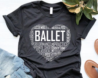 Peut inclure: T-shirt noir avec un motif en forme de cœur blanc comportant le mot "BALLET" entouré de mots liés au ballet, tels que "performance", "pointe shoe", "rhythm" et "rehearsal".