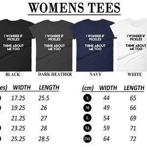 May include: A size chart for women's t-shirts with the text "I wonder if pickles think about me too" printed on the shirts. The chart shows the width and length of the shirts in inches and centimeters for sizes S, M, L, XL, and 2XL. The shirts are available in black, dark heather, navy, and white.