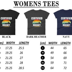 May include: A size chart for women's t-shirts with the text "Certified Magnet Fisherman" in a vintage sunset graphic. The chart shows measurements in inches and centimeters for sizes S, M, L, XL, and 2XL. The t-shirts are available in black, dark heather, and navy.
