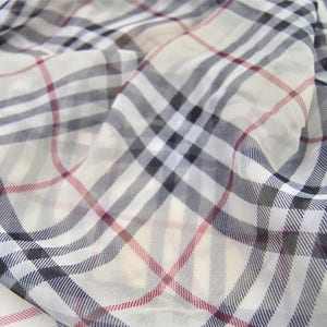 May include: White sheer fabric with a black and red plaid pattern.