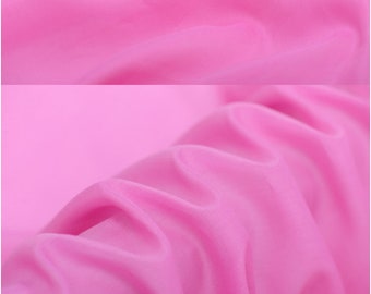 May include: Close-up of a vibrant pink fabric with soft folds and a silky texture. The fabric is a solid color, with the text "silkfabricdesigns.etsy.com" at the bottom. The fabric is likely silk or a similar material.