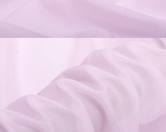 May include: A close-up of a pale pink silk fabric. The fabric is smooth and has a slight sheen. The fabric is folded in several places, showing the drape and texture. The text "silkfabricdesigns.etsy.com" is visible in the image.