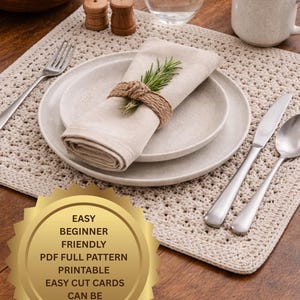Puede incluir: Un mantel individual beige tejido a ganchillo con un cubierto, que incluye un plato, una servilleta y cubiertos. Una ramita de romero adorna la servilleta, asegurada con hilo. También hay una taza de café, un vaso de agua y un cuenco de madera.