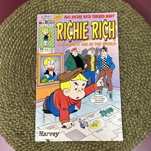 May include: A vintage "Richie Rich" comic book cover. The cover features a cartoon illustration of Richie Rich, the richest kid in the world, with a map and text that reads "This is my plan to rob the rich mansion!"