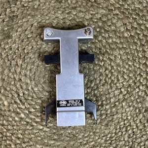 May include: A silver-colored metal integrated circuit extraction tool with black plastic side grips. The device features a T-shaped top with two screws and a central label reading OK INDUSTRIES INC. MODEL EX-2, YONKERS, N.Y. 10701 U.S.A. PATENTED MADE IN TAIWAN R.O.C.