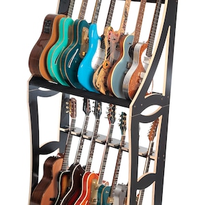 May include: A black wooden guitar rack displaying a variety of electric and acoustic guitars. The guitars are in various colors, including natural wood, blue, and teal. The rack has two levels and holds approximately 15 guitars.