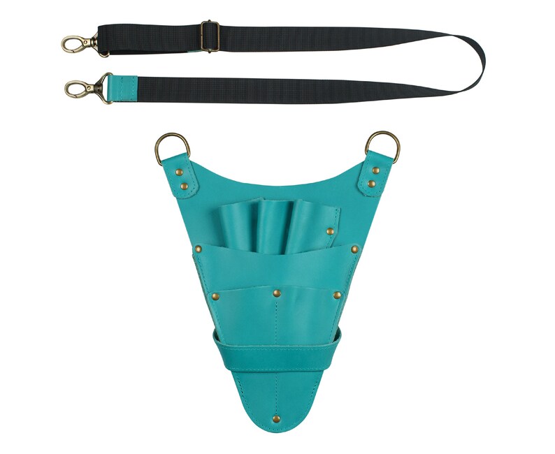 K&ouml;nnte beinhalten: T&uuml;rkiser Ledertaschenhalter f&uuml;r Scheren mit verstellbarem Riemen. Der Halter hat mehrere Taschen zum Aufbewahren von Scheren und anderen Werkzeugen.