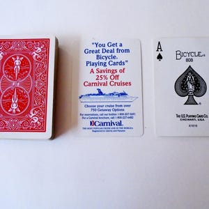 May include: A deck of red Bicycle playing cards with an intricate back design, a white promotional card for Carnival Cruises with blue and red text, and an Ace of Spades playing card featuring the Bicycle logo and the U.S. Playing Card Co. text.
