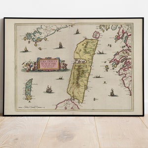May include: An antique map of the Isle of Jura, printed in brown, green, and red ink on a cream-colored background. The map is framed in black and features the text "JURA INSULA The Isle of JURA" in a pink rectangle.
