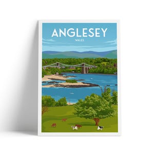 Puede incluir: Una impresión enmarcada que presenta un paisaje de Anglesey, Gales. La imagen muestra un puente sobre un río azul, con colinas verdes y árboles en el fondo. Las vacas pastan en un campo verde en primer plano. La palabra "Anglesey" está en la parte superior.
