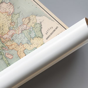 May include: An antique map of Europe, with a white rolled edge. The map features detailed illustrations of countries and regions in various colors. The text "BETTS'S IMPROVED EDUCATIONAL MAPS" is visible. The map is partially rolled.