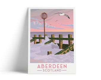 Pode incluir: Uma impressão emoldurada com uma cena costeira com um quebra-mar de madeira, ondas quebrando e uma gaivota em voo contra um pôr do sol rosa e laranja. A impressão inclui o texto "Aberdeen - Scotland" em rosa.