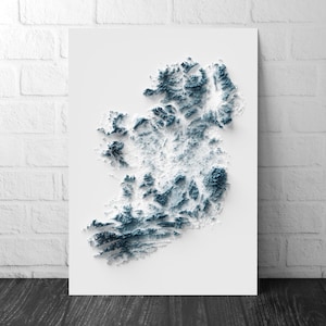 Pode incluir: Um mapa topográfico emoldurado da Irlanda, em tons de branco e azul-petróleo. O efeito 3D destaca o terreno variado do país, criando uma representação visual marcante da nação insular. O mapa é montado em um fundo branco.