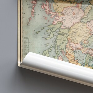May include: An antique map of Scotland, featuring detailed geographical information and historical cartography. The map displays various regions with different colors, and is partially rolled up, revealing a white edge. The map is set against a gray background.