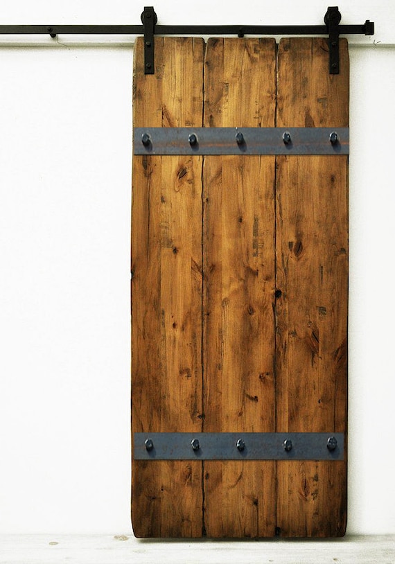 Puerta corredera realizada con un tablón macizo de madera, el