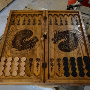 May include: Wooden backgammon board with dragon artwork. The light brown wooden board features a dragon design on each side. Includes wooden game pieces and dice for play.